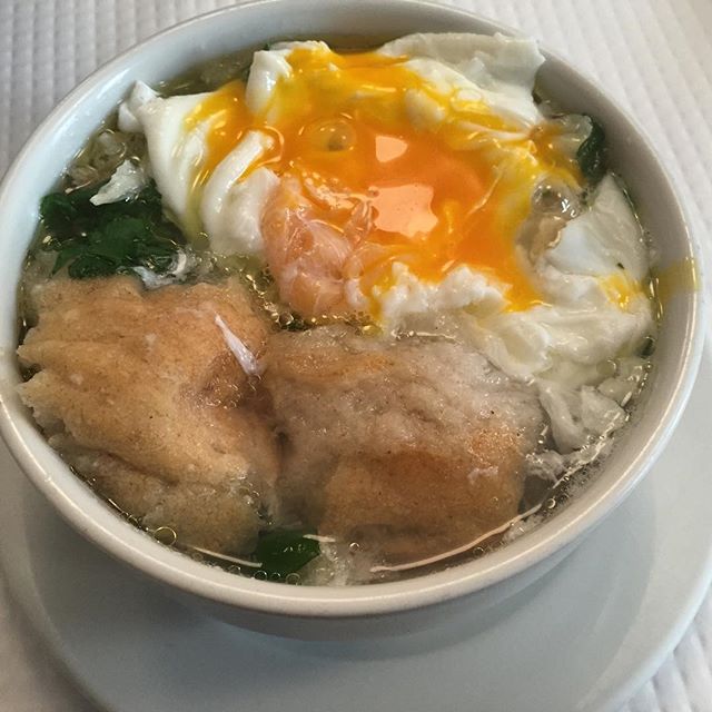 Simple galic and water broth with olive oil, poached egg, cilantro, and bread. Once the egg is broken and mixed with the soup, the broth becomes creamy, not filled with chunks of cooked yolk, as you might expect.